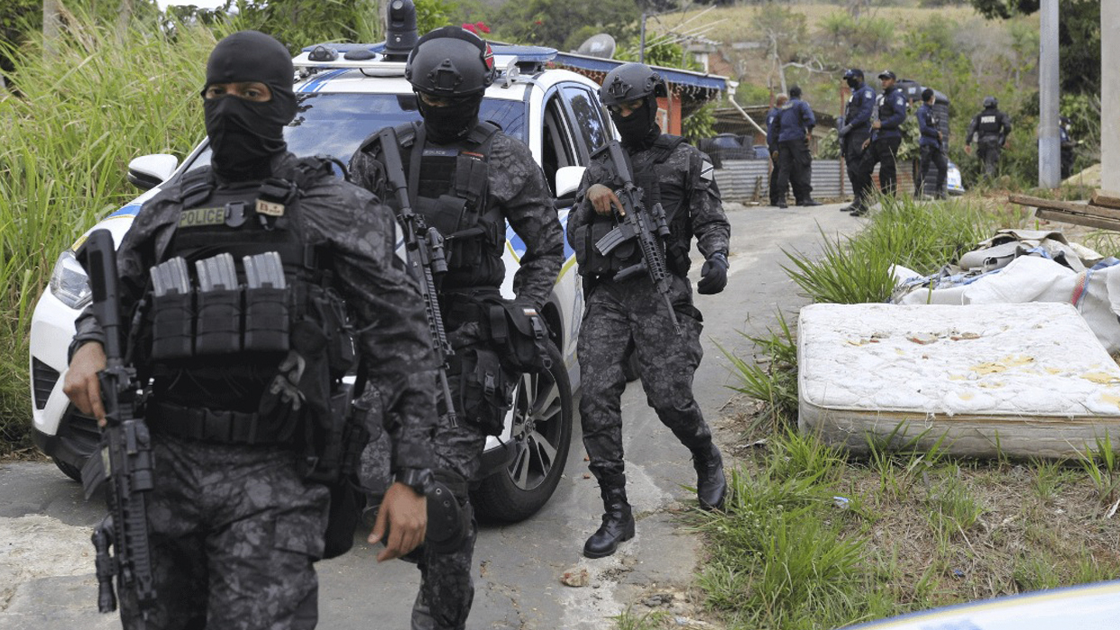 Fuerzas policiales en Trinidad y Tobago escoltan a los detenidos acusados de formar parte de una red de trata de personas (Foto cortesía)