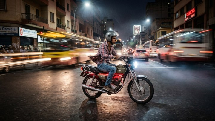 Una motocicleta circula a alta velocidad por una avenida céntrica. Las motos están involucradas en más de la mitad de los accidentes mensuales en Venezuela. (Imagen generada por IA)
